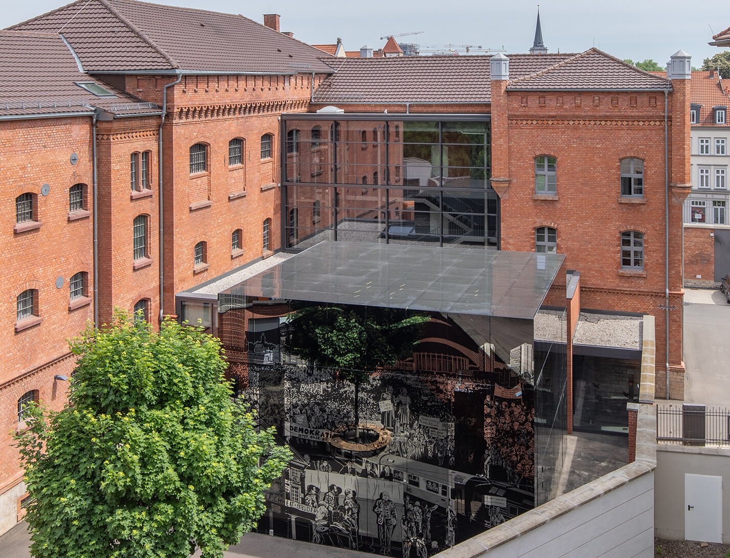 a full view of the former prison building and the cube of the Peaceful Revolution
