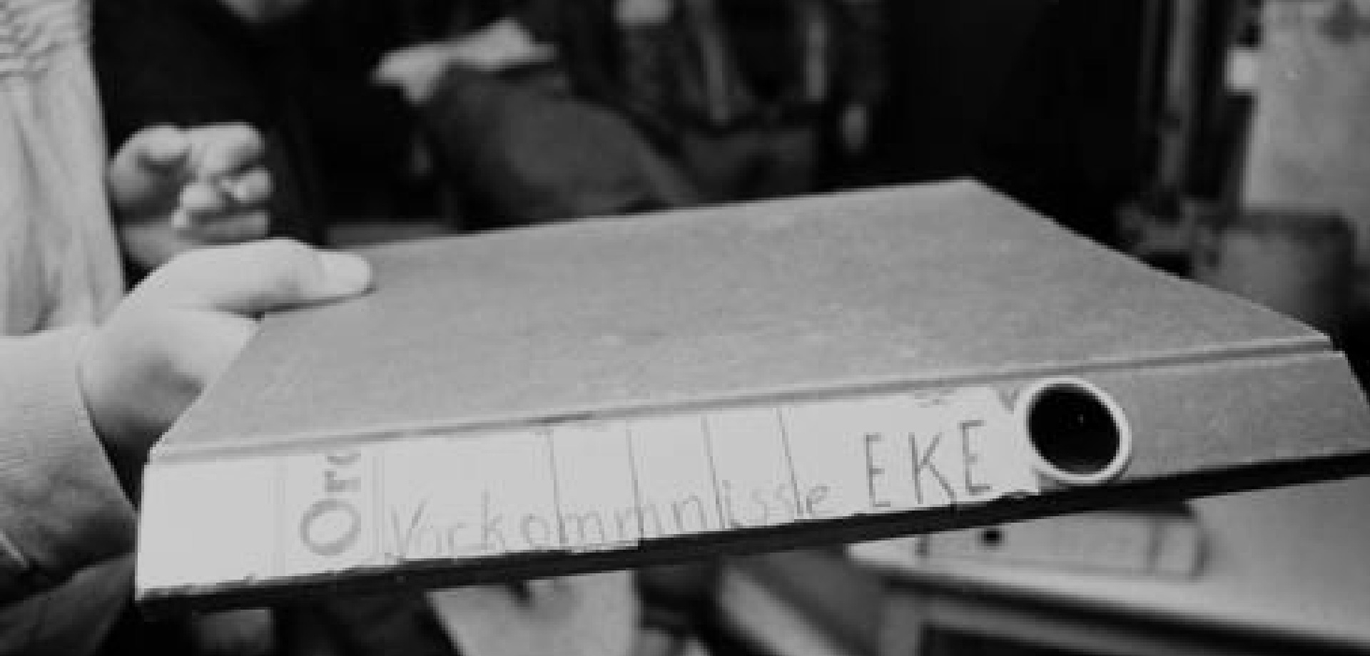 ein Aktenordner wird von einer Hand in die Kamera gehalten, er sit leer, auf dem Ordner steht "Vorkomnisse EKE"